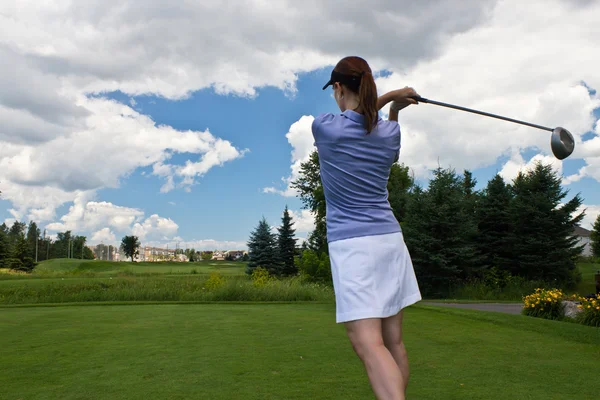 Golfista feminina balançando seu taco de golfe — Fotografia de Stock
