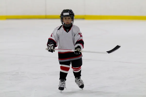 Kleine jongen die ijshockey speelt — Stockfoto