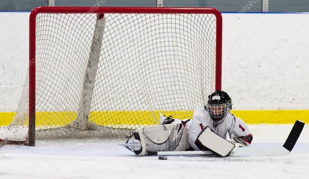 Child hockey goalie making a save