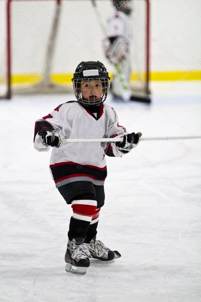 Child playing minor hockey in the arena