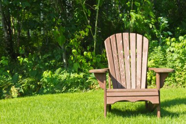 Adirondack summer lawn chair outside on the green grass clipart
