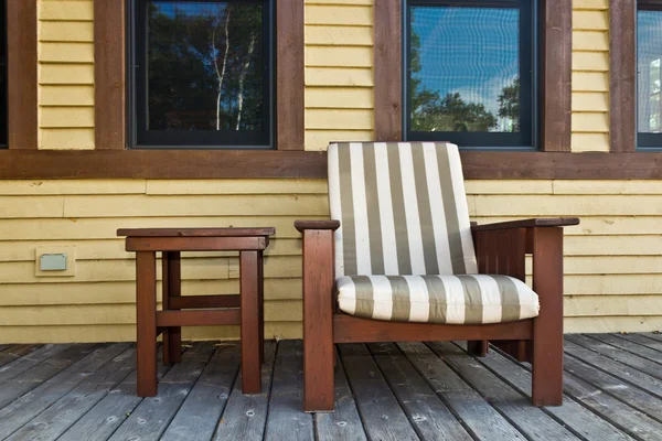 Chair on a wooden deck at a cottage — Stock Photo, Image