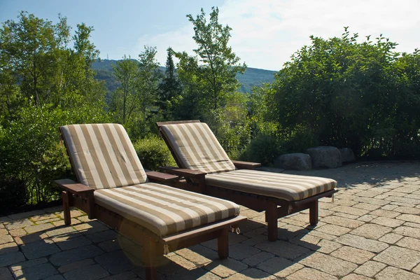 Um par de cadeiras de gramado de banho de sol fora em um convés — Fotografia de Stock