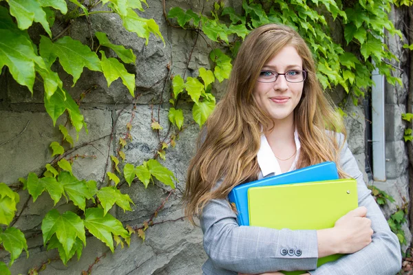 Schoolmeisje met haar boeken op de campus — Stockfoto