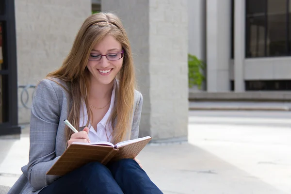 Happy woman writing in her journal — Stock Photo, Image