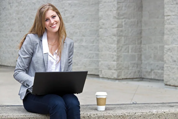 Friendly woman working on laptop outside — Stock Photo, Image