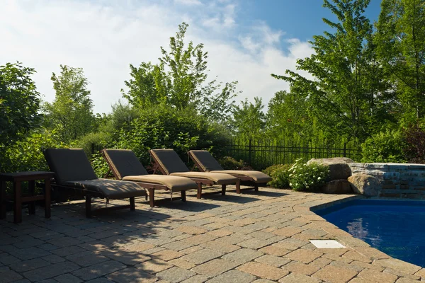 Gtoup of sunbathing lawn chairs on a pool deck Stock Image