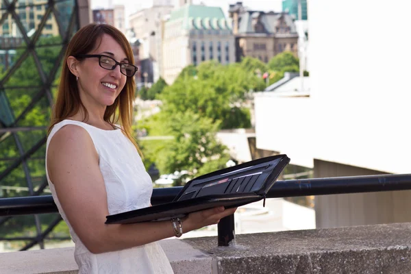 Vrouw met map op een stad balkon — Stockfoto
