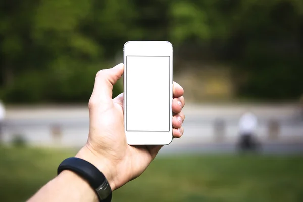 Homem usando telefone celular no parque como câmera Fotos De Bancos De Imagens