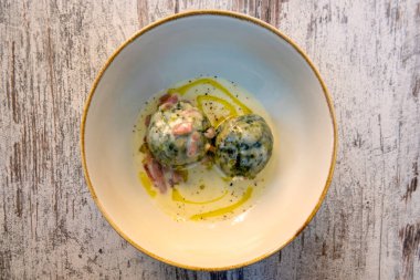 Traditional Tyrolean spinach knodel with cream cheese and speck