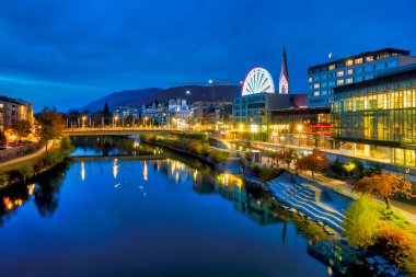 View of the river Drau with the Congress Center, the ferris wheel and the bell tower of the Nikolaikirche