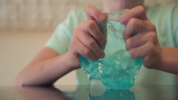 Großaufnahme von Kinderhänden, die mit Schleim spielen. Blauer transparenter Schleim, modisches Spielzeug. Antistress für das Kind — Stockvideo