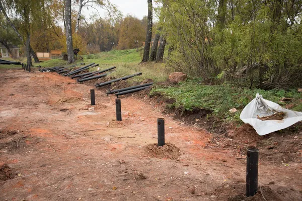 En el sitio de construcción. Montones de cimientos. Algunas de las pilas ya están en el suelo, algunas de las pilas aún no han sido arrojadas al suelo. Proceso de instalación de Fundación. Moderno — Foto de Stock