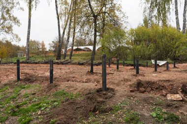 İnşaat alanında. Temel yığınları. Yığınların bir kısmı zaten toprağa gömülmüş, bir kısmı henüz toprağa gömülmemiş. Kurulum süreci. Modern