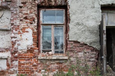 Terk edilmiş bir binada eski bir tuğla duvar. Kapı aralığı. Kırık pencere