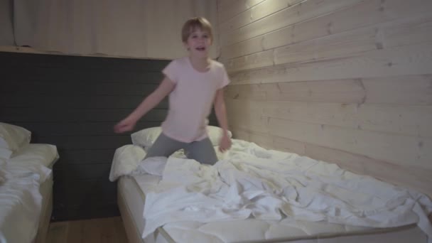 Ein glückliches Kind tanzt in der Dämmerung. Das Mädchen tanzt im Bett. Gute Laune und Glück. — Stockvideo