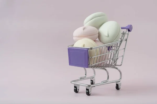 다양 한 색상의 마시멜로가 쇼핑 트롤리에 있다. 여러 가지 색깔의 감미 로움. 마시멜로 쇼핑 컨셉이야. 제품의 품질 — 스톡 사진