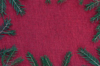 Noel arkaplanı. Kırmızı çuval bezi, Noel ağacının dalları. Kartpostal, davet, arkaplan, metin için yer