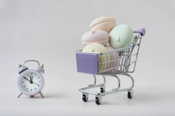 쇼핑 바구니에 마시멜로가 있다. 근처에 시계가 있다. 식품의 유통 기한을 정하는 개념입니다. 해적판 — 스톡 사진