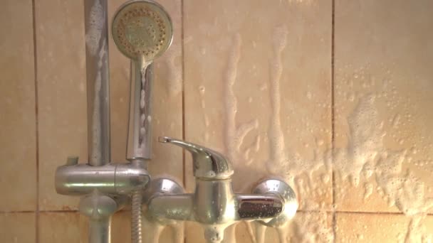 Processen att applicera rengöringsmedel på väggarna i duschen. Vitt skum appliceras på gula smutsiga väggar. Förstöring av gula smutsiga plack. Vatten med hög halt av järn och kalciumblad — Stockvideo