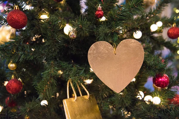 A árvore de Natal está decorada com um coração dourado. O conceito de uma declaração de amor. Amor e cuidado. Dia dos Namorados. — Fotografia de Stock