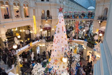 Moskova, Rusya - Aralık 2021: GUM, Noel ve Yeni Yıl için iç dekorasyon. Mağazanın ana ağacı. Beyaz, büyük bir ağaç. Şenlik havası. En üst kattan görüntüle.