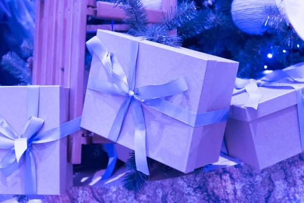 Krabice s dárky pod stromem. Barva trendu z roku2022. Fialové a modré odstíny. — Stock fotografie