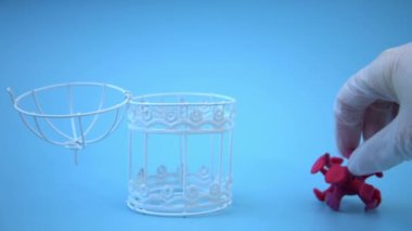 Tıbbi eldivendeki bir el, virüsü metal bir kafese yerleştirir. Coronavirüs 'ü yenme konsepti. Virüsün aşısı ve tedavisi. Bir doktorun işi, bir aşı üreticisinin işi, bir