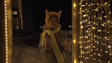 Noel boynuzlu bir çocuk Yeni Yıl çelenkleri arasında dans eder. Noel 'de ve yeni yılda iyi bir ruh hali. Eğlence ve dans.