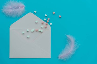 Hassas mavi gölgeler. Sevgililer günü için kartpostal, düğün davetiyesi, nişan, doğum günü. Renkli kalpler, tüyler ve mavi arka planda bir zarf..