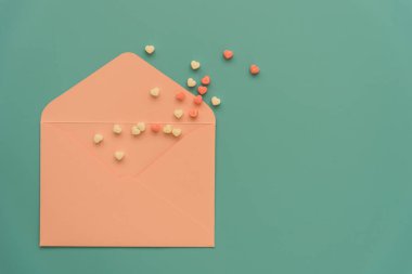 Parlak turkuaz arka planda pembe bir zarf. Mesajlaşmak için yeri olan temiz bir zarf. Sevgililer günü kartı ya da davetiye tasarımının temeli. Düğün davetiyesi, doğum günü, nişan ve dahası.