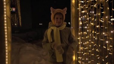 Noel boynuzlu bir çocuk Yeni Yıl çelenkleri arasında dans eder. Noel 'de ve yeni yılda iyi bir ruh hali. Eğlence ve dans.