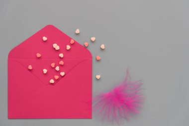 Sevgililer Günü için şık bir tebrik kartı. Gri bir arka planda, parlak kırmızı bir zarf ve hassas kalpler. Mesaj için yer var. Sıra dışı tasarım.