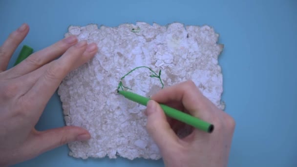 Vrouwenhanden tekenen een teken van hergebruik met een groene viltstift. Tekenen op gerecycled papier. Herbruikbaar papier, achtergrond, textuur. Milieuzorg, ecologie. — Stockvideo