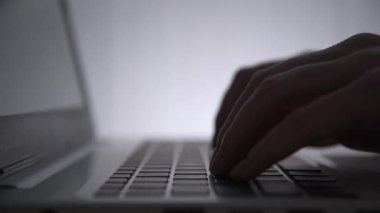 Karanlıkta hackerların elleri klavyede çalışır. Siber suçlar. Bir kişi geceleri bir dizüstü bilgisayarda çalışır. Gizem ve sır kavramı. Seçici odaklanma, yumuşak odaklanma