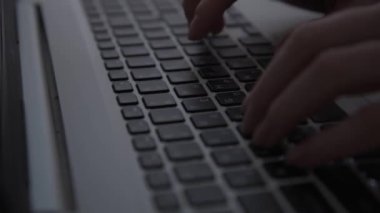 Karanlıkta hackerların elleri klavyede çalışır. Siber suçlar. Bir kişi geceleri bir dizüstü bilgisayarda çalışır. Gizem ve sır kavramı. Seçici odaklanma, yumuşak odaklanma