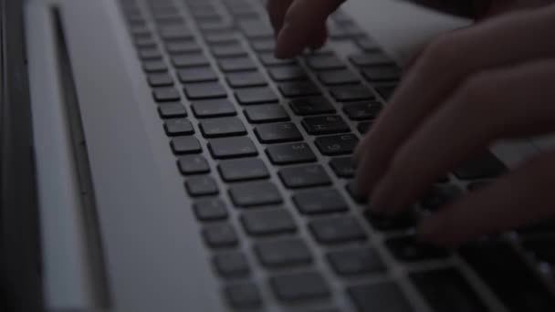 In het donker, de hackers handen werken op het toetsenbord. Cybermisdaden. Een persoon werkt 's nachts op een laptop. Het concept van mysterie en geheimen. Selectieve focus, zachte focus — Stockvideo