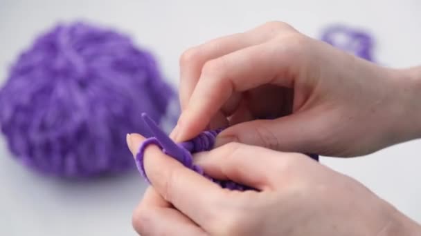 The process of knitting. Close-up of womens hands. Knitting. Selective focus. In the background is a ball of yarn. Fashionable trendy purple yarn color. — Stock Video