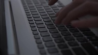 Karanlıkta hackerların elleri klavyede çalışır. Siber suçlar. Bir kişi geceleri bir dizüstü bilgisayarda çalışır. Gizem ve sır kavramı. Seçici odaklanma, yumuşak odaklanma