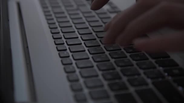 En la oscuridad, las manos de los hackers trabajan en el teclado. Delitos cibernéticos. Una persona trabaja en un portátil por la noche. El concepto de misterio y secretos. Enfoque selectivo, enfoque suave — Vídeos de Stock