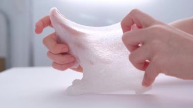 Çocukların elleri, yakın plan. Çocuk yapışkan bir oyuncakla oynuyor. Stres atmak. Güzel oyuncak. Rahatlama ve iyileşme.