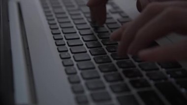Karanlıkta hackerların elleri klavyede çalışır. Siber suçlar. Bir kişi geceleri bir dizüstü bilgisayarda çalışır. Gizem ve sır kavramı. Seçici odaklanma, yumuşak odaklanma