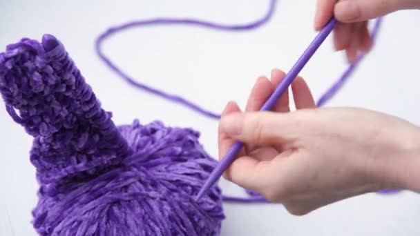 Großaufnahme von Frauenhänden. Eine Frau nimmt Stricknadeln und beginnt zu stricken. Garn modische lila Farbe. Selektiver Fokus auf die Hände. — Stockvideo