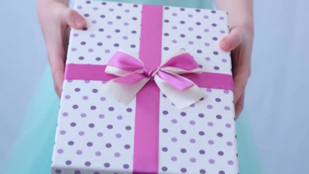 Barnens händer är närbilder. Ett barn i en aftonklänning rymmer en låda med presenter. Begreppet gåva, en överraskning. Vacker låda — Stockvideo