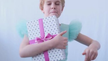 Gece elbisesi giymiş güzel bir kız elinde bir hediyeyle dans ediyor. Alınan hediye ve bayramın neşe ve mutluluğu. Çocukların yüzündeki duygular.