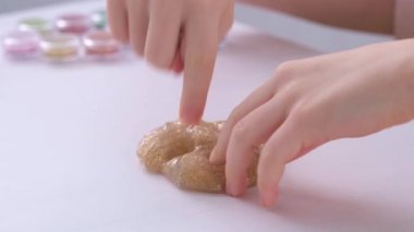 Çocukların elleri, yakın plan. Çocuk altın sümükle oynuyor. Stres önleyici oyuncak. Yumuşak dokunuşlar, hoş duygular.