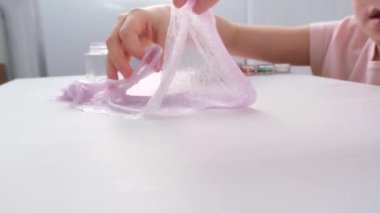 Çocukların elleri, yakın plan. Çocuk yapışkan bir oyuncakla oynuyor. Stres atmak. Güzel oyuncak. Rahatlama ve iyileşme.