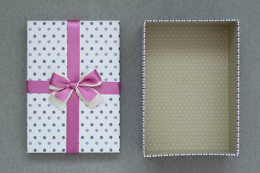 Yukarıdan bak. Gri süet arka plandaki hediye kutusunu aç. Yanındaki kutunun kapağı.