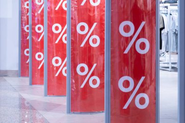 Alışveriş merkezi. Alışveriş merkezinin girişindeki hırsızlıkla mücadele sensöründe kırmızı parlak kelime pankartı. Mağazada mevsimlik indirim teklifi