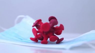 Koronavirüs bir maskeye takıldı. Coronavirus 'un şekli tıbbi bir maskenin içinde yatıyor. Tüm bileşim döner, her yönden izlenebilir..